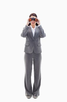 Businesswoman looking through binoculars against white background