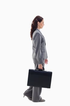 Profile of a businesswoman walking with a briefcase against white background