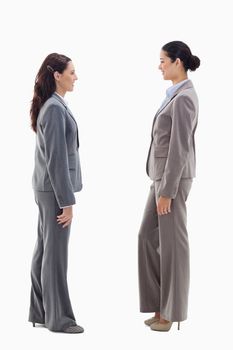 Two businesswomen smiling face to face against white background