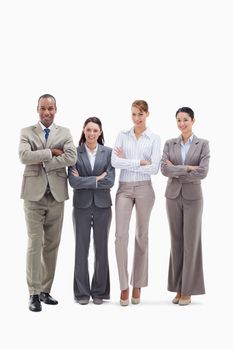 Business team smiling side by side and crossing their arms against white background