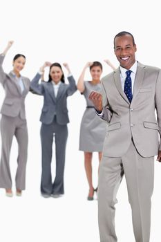 Successful business team with a happy businessman in foreground and three enthusiastic co-workers raising their arms