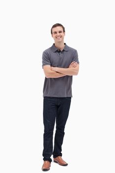 Standing man smiling while crossing his arms and against white background