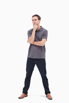 Thoughtful standing man with his legs apart against white background