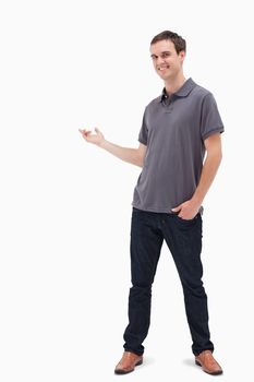 Happy man standing and presenting something behind against white background