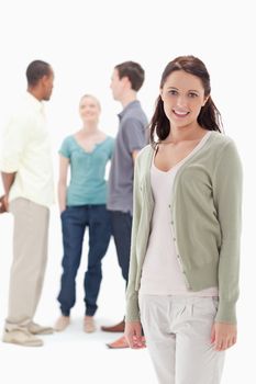 Woman smiling with her friends chatting behind against white background