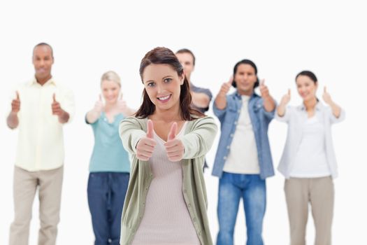 Close-up of people with their thumbs-up focus on the woman in foreground