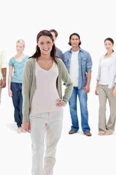 Close-up of people behind a smiling woman with her hand on her hip against white background