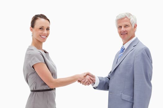 Close-up of a white hair man face to face and shaking hands with a woman against white background