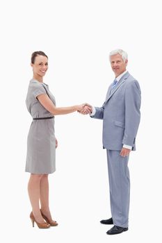 White hair man face to face and shaking hands with a woman against white background