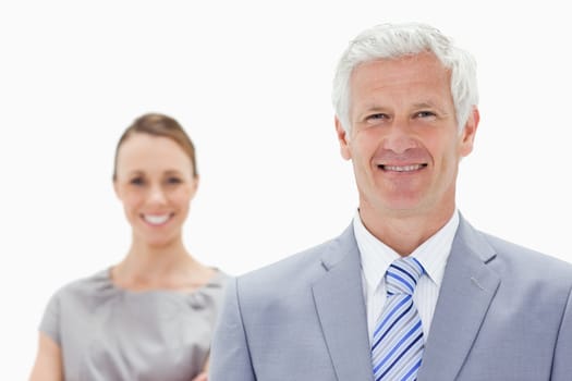 Close-up of a happy white hair businessman with a woman smiling behind him against white background
