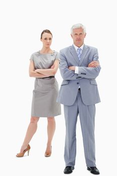 White hair businessman with a woman behind him crossing their arms against white background