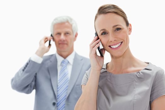 Close-up of a smiling woman making a call with a white hair man in background