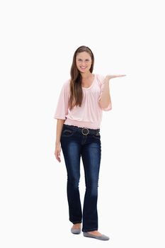 Smiling young woman presenting against white background