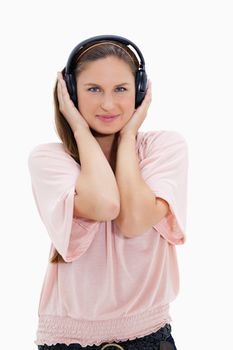 Girl with pink shirt wearing headphones against white background