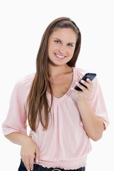 Close-up of a girl holding a mobile phone against white background