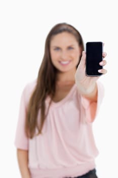 Close-up of a girl showing a smartphone with focus on the screen against white background