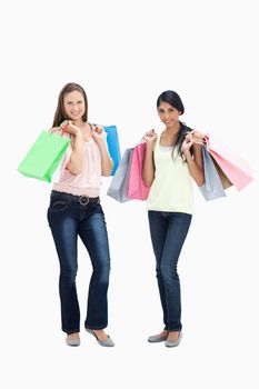 Girls smiling with shopping bags against white background