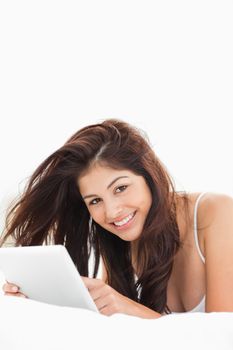 A close up shot showing a woman using a tablet while looking up and smiling. 