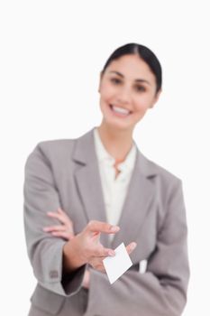 Business card being handed over by smiling saleswoman against a white background