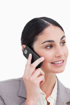 Close up of businesswoman talking on her cellphone against a white background