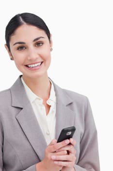 Close up of smiling businesswoman holding cellphone against a white background
