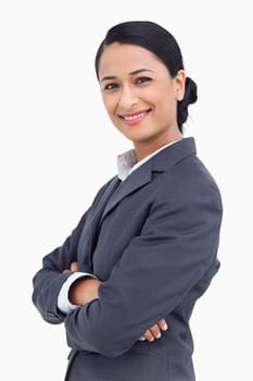 Close up of smiling saleswoman with arms crossed against a white background