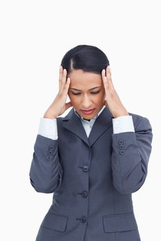 Close up of saleswoman rubbing her temples against a white background