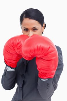 Close up of belligerent saleswoman with boxing gloves against a white background
