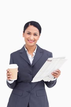 Close up of smiling saleswoman with paper cup and newspaper against a white background
