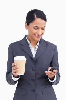 Close up of saleswoman with paper cup reading text message against a white background