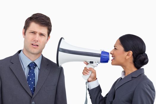 Close up of saleswoman with megaphone yelling at colleague against a white background