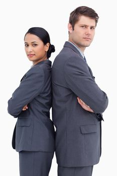 Close up of confident salesteam standing back to back against a white background