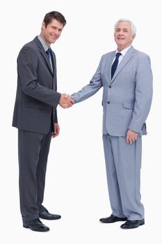 Side view of businessmen shaking hands against a white background