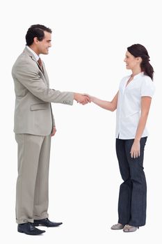 Side view of business people shaking hands against a white background