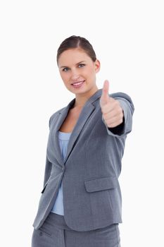 Smiling tradeswoman giving thumb up against a white background