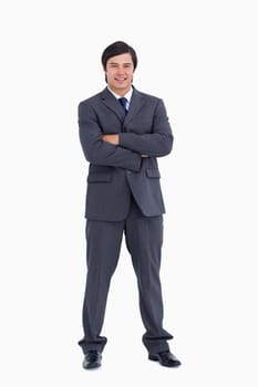 Smiling tradesman with his arms folded against a white background