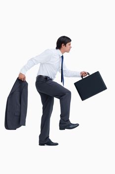 Side view of walking tradesman with suitcase and jacket against a white background