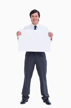 Smiling tradesman holding blank sign against a white background