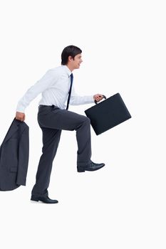 Side view of walking tradesman with jacket and suitcase against a white background