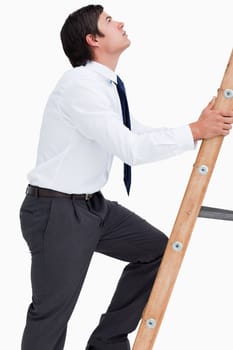 Side view of tradesman climbing a ladder against a white background