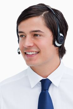 Close up of smiling male call center agent looking to the side against a white background