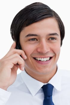 Close up of smiling tradesman on his cellphone against a white background
