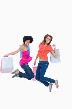 Dynamic teenagers energetically leaping after going shopping