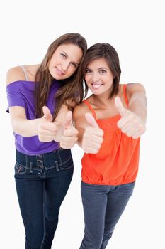 Teenagers putting their thumbs up with beaming smiles