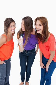 Teenagers singing karaoke and laughing with friends