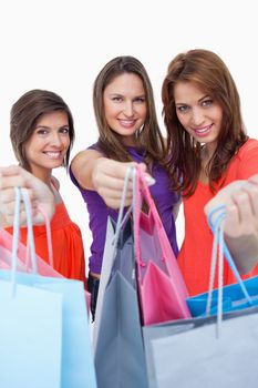 Teenagers showing their purchases in front of the camera while smiling