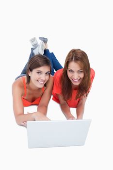 Teenagers crossing their legs while lying down behind a laptop