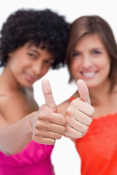 Thumbs up showed by two smiling teenage friends