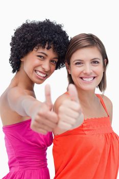 Teenagers proudly putting their thumbs up against a white background