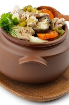 Chicken Stew, Vegetables and Greens in Brown Pot with Wooden Spoon isolated on white background